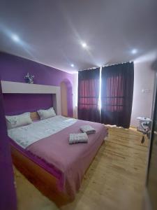 萨帕雷瓦巴尼亚Стаи за гости Върбите的一间卧室配有一张紫色床和两条毛巾
