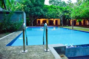 锡吉里亚Tropicara Resort的一座大型游泳池,里面设有两个金属棒