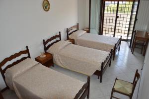 钱皮诺Domus Achille Fosco的一间设有四张床和一张桌子及椅子的房间