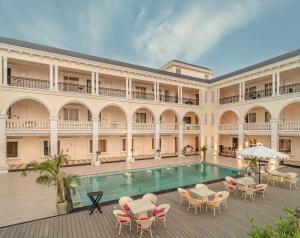 SītāpurRudra Imperial Resort的一座带游泳池和桌椅的大型建筑