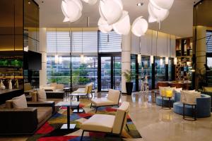 突尼斯Tunis Marriott Hotel的大堂配有沙发椅、桌子和窗户。