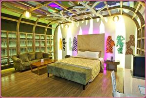 六龟薇风精品汽车旅馆 - 高雄馆的一间卧室配有一张床、一张沙发和一台电视。