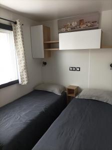 鲁西隆地区卡内Mobil home moderne neuf et ultra équipé de 6 à 8 couchages的小型客房 - 带2张床和窗户