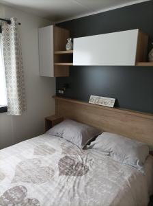 鲁西隆地区卡内Mobil home moderne neuf et ultra équipé de 6 à 8 couchages的一间卧室配有一张带木制床头板的床