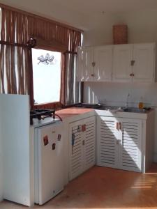 拉斯特拉纳斯NEW MORINGA的厨房配有白色橱柜和窗户。
