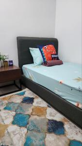 哥打丁宜Haiqal's Hometay @ Desaru (Muslim)的一张带枕头的床和一张地毯