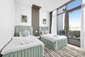 迪拜StoneTree - Anwa By Omniyat 2BR - Luxury Apartment的酒店客房设有两张床和大窗户。
