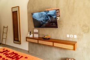 坎古Roomates Hostel Canggu by Ini Vie Hospitality的墙上配有平面电视的房间