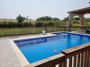 Tal ShaẖarVilla with a pool in a beautiful garden的一个带木栅栏的游泳池