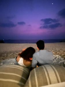 乌杜皮The Postcard on the Arabian Sea的坐在海滩上一对夫妇,望着大海