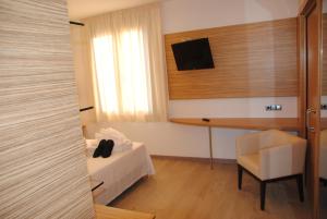滨海托萨维多利亚酒店的客房设有一张床、一张桌子和一把椅子。