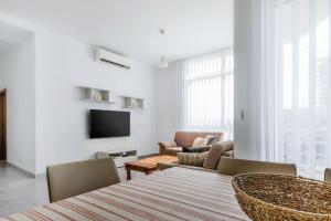 埃尔哥茨拉Bright Apartment minutes from the Sea的客厅配有桌椅和电视。