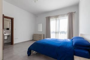 埃尔哥茨拉Bright Apartment minutes from the Sea的一间卧室设有蓝色的床和窗户。