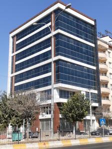 GrandPazarcıkOtel的街道上带蓝色窗户的办公楼