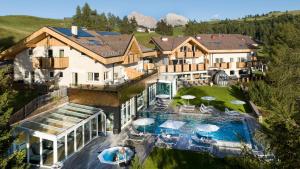 阿尔卑斯休斯山Hotel Rosa Eco Alpine Spa Resort的享有带游泳池的房屋的空中景致