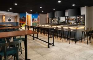 月球乡希尔顿逸林酒店匹兹堡机场店的一间带桌椅的餐厅和一间酒吧