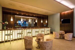 丹吉尔丹吉尔市中心希尔顿花园酒店的餐厅内的酒吧配有椅子和柜台