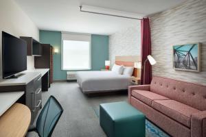 里士满Home2 Suites By Hilton Richmond Glenside的酒店客房,配有床和沙发