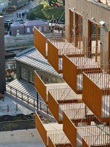 特罗姆瑟TotalApartments Vervet Gjøa, brand new apartments的一座建筑的图象,有橙色的楼梯