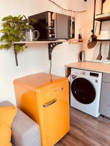 波鸿The Room - Direkt in der Stadt!的厨房配有微波炉旁的橙色冰箱