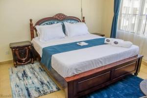 尼亚利Lux Suites Impala Apartments Nyali的一间卧室配有一张床,上面有两条毛巾