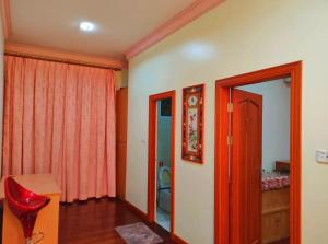 诗巫R&S Homestay Sibu - Wedding House with Large Parking Area and High Speed Unifi的一间设有红色椅子、一张桌子和一面镜子的客房