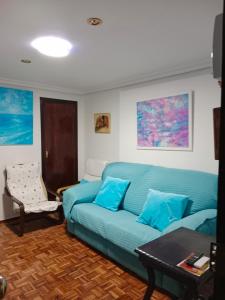 塞维利亚Apartamento zona Palacio de las Dueñas y las Setas的客厅配有蓝色的沙发和桌子