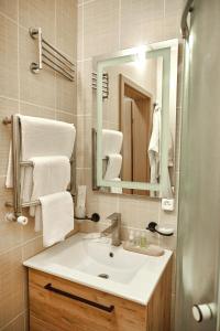 克洛佩夫尼茨基Готель Зірка的浴室配有盥洗盆、镜子和毛巾