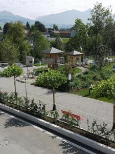 阿彭策尔Ferienzimmer Appenzell的公园里的一个花园,有红色长凳