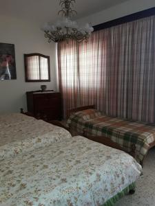 萨奈特Villa Palma的一间卧室配有两张床和吊灯。