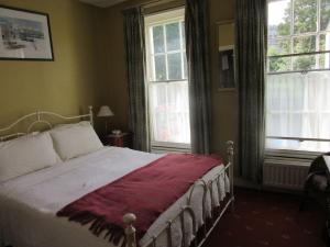 伦敦德里Cathedral Cottage的一间卧室配有一张床铺,床上铺有红色毯子