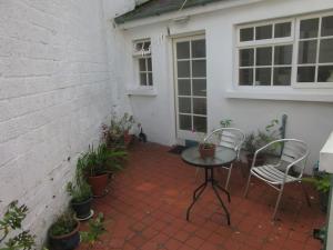 伦敦德里Cathedral Cottage的庭院配有两把椅子和一张桌子,还有一些植物