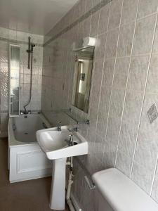 LlangristiolusHolland arms hotel的浴室配有盥洗盆和浴缸。