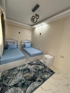 赫尔格达Apartment Hossam 1的一间带两张床的卧室和地毯