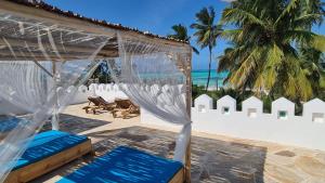 江比阿Kholle Villa的海滩上的大帐篷,配有蓝色的椅子和海洋