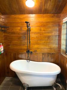 福兴薔薇谷 民宿字108號的带浴缸的浴室,设有木墙