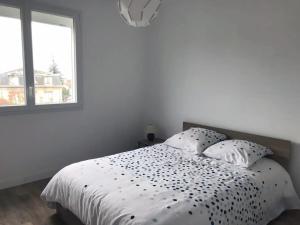 洛尔蒙Superbe appartement proche Bordeaux pied du tram的卧室配有一张带两个枕头的白色床,卧室设有窗户