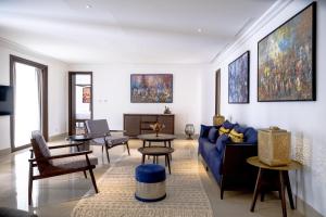 杜兹The Residence Douz的客厅配有蓝色的沙发和椅子