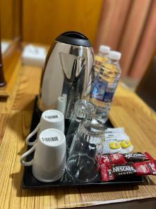 沙迦Al Ghadeer Hotel Apartment的一个带咖啡壶和茶几上的杯子的托盘