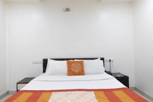 孟买Hotel Amber Suite Near Mumbai Airport的床上有橙色枕头