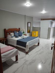 卢米亚Pousada Hotel Lumiar的一间铺有大理石地板的卧室,配有两张床