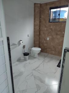 卢米亚Pousada Hotel Lumiar的白色的浴室设有卫生间和水槽。