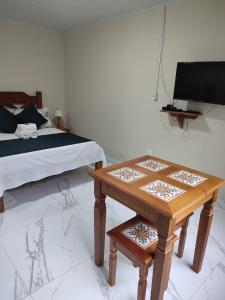 卢米亚Pousada Hotel Lumiar的一间卧室配有一张床、一张桌子和一张床