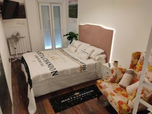 洛格罗尼奥Gran Reserva Suites centro alojamiento entero的一间卧室配有一张床、一把椅子和一张沙发