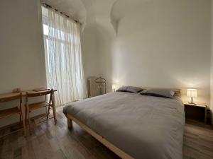 库尼奥Al Belvedere Affittacamere的一间卧室配有一张床、一张书桌和一个窗户。