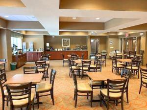 棕榈海岸Palm Coast Hotel & Suites-I-95的一间带木桌椅的餐厅和一间厨房