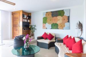 苏梅岛Villa Stella 16 Santi Thani Maenam的客厅配有两张沙发和一张带红色枕头的桌子