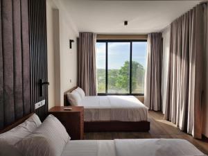 维勒珀图Thimbiri Wewa Resort Wilpattu的酒店客房设有两张床和大窗户。