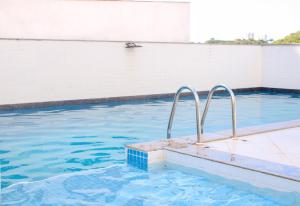 萨尔瓦多Axé home - Apartamento conceito em Salvador的一个带蓝色水和金属栏杆的游泳池