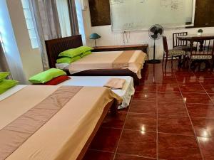 马尼拉MARIKINA 32 sqm Studio for Transients w WiFi 40 inch TV Parking的带3张床和桌子的房间